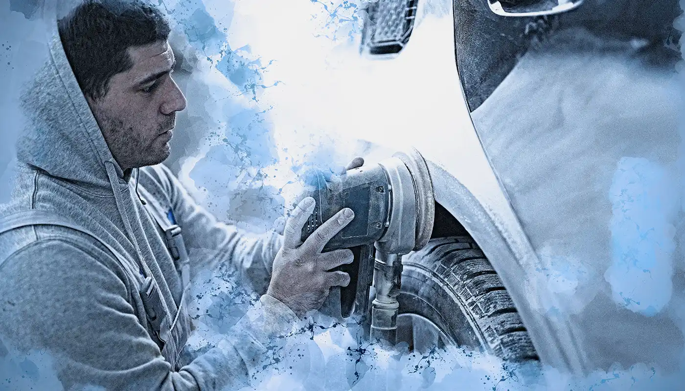 Mann schleift den Lack eines Autos mit der Schleifmaschine